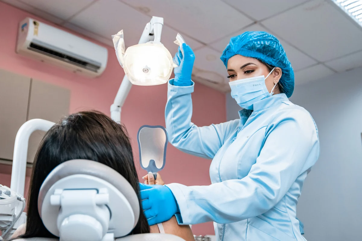 A woman dentist examining a patient in a dental chair